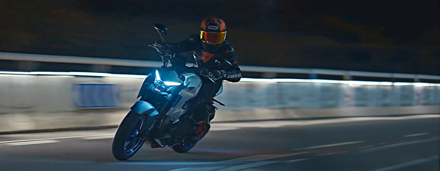 Zontes motos en Argentina - Rider con Zontes 350R gris inclinando de noche sobre asfalto mojado.