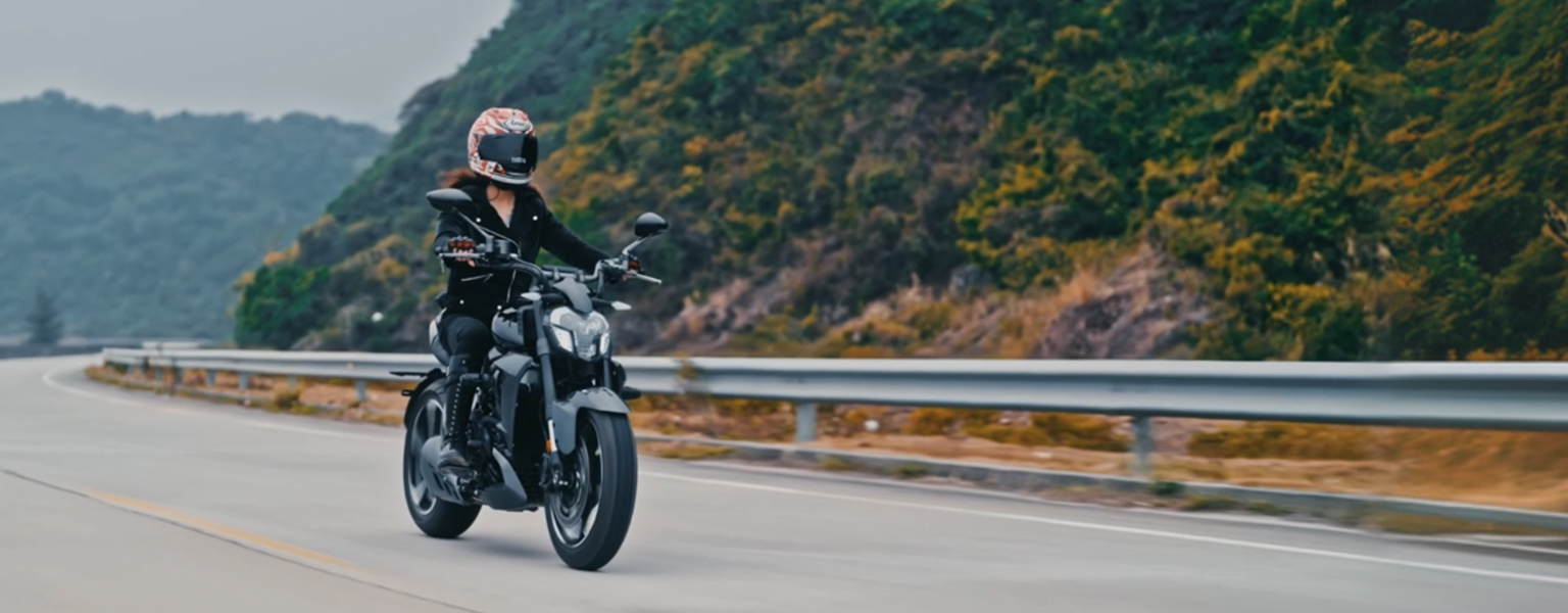 Zontes motos en Argentina - Zontes 350V gris siguiendo una curva de ruta junto a la ladera, con piloto equipado para carretera.