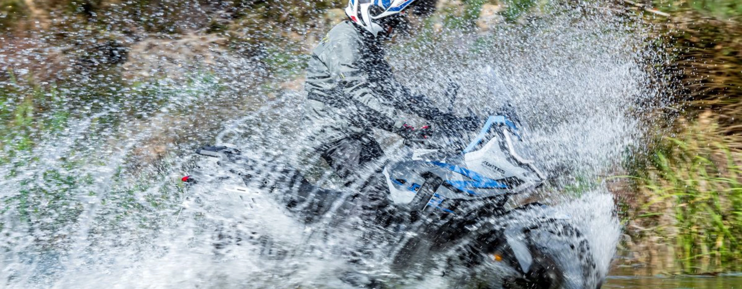 Zontes motos en Argentina - Moto Zontes 703F en paso de agua con piloto de casco y equipamiento de aventura. Zontes motos en Argentina - Zontes 703F atravesando agua con conductor equipado y salpicaduras alrededor de la moto.