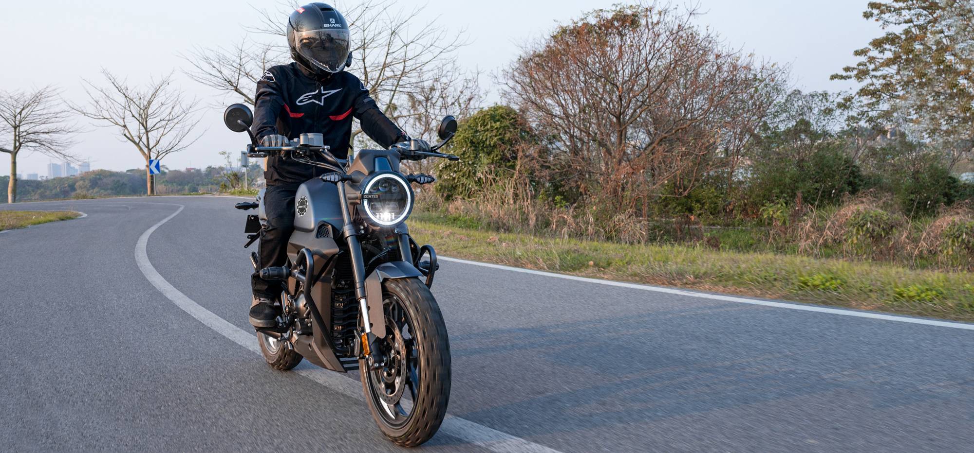 Zontes motos en Argentina - Moto Zontes 200G rodando en una curva con piloto de casco integral y faro encendido. Zontes motos en Argentina - Zontes 200G en movimiento con conductor equipado sobre una curva asfaltada.