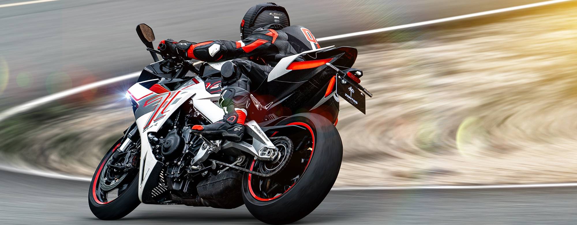 Zontes motos en Argentina - Zontes 703RR avanzando con decision sobre la pista, con carenado envolvente y una postura claramente sport. Zontes motos en Argentina - Zontes 703RR en marcha rapida con faro encendido, piloto inclinado y una silueta blanca con acentos rojos muy visibles.