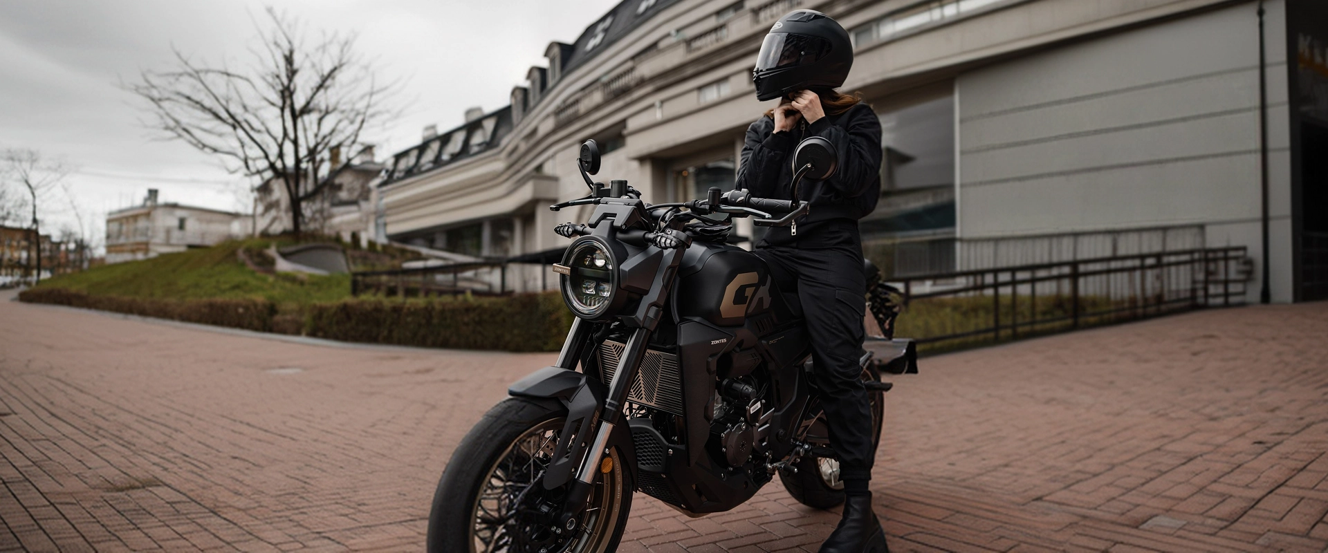 Zontes motos Argentina - Zontes 350GK con uso urbano cotidiano Zontes motos Argentina - moto Zontes 350GK negra junto a una persona ajustándose el casco