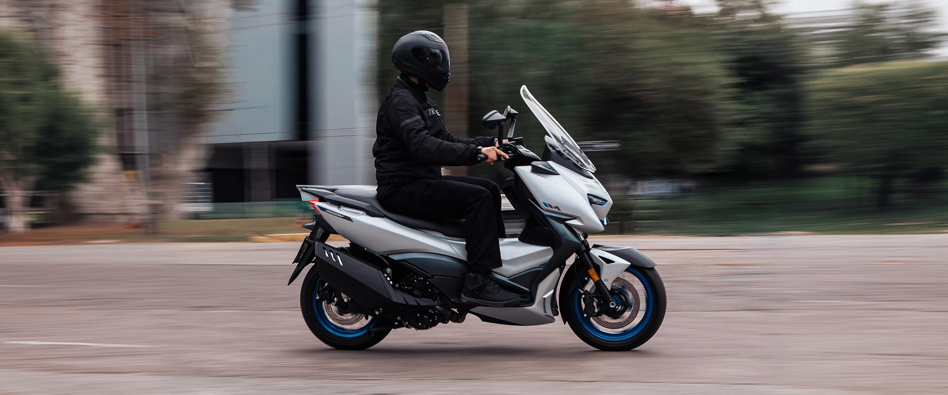 Zontes motos Argentina - Zontes 368M en movimiento urbano Zontes motos Argentina - scooter Zontes 368M blanco circulando con conductor equipado y llantas azules