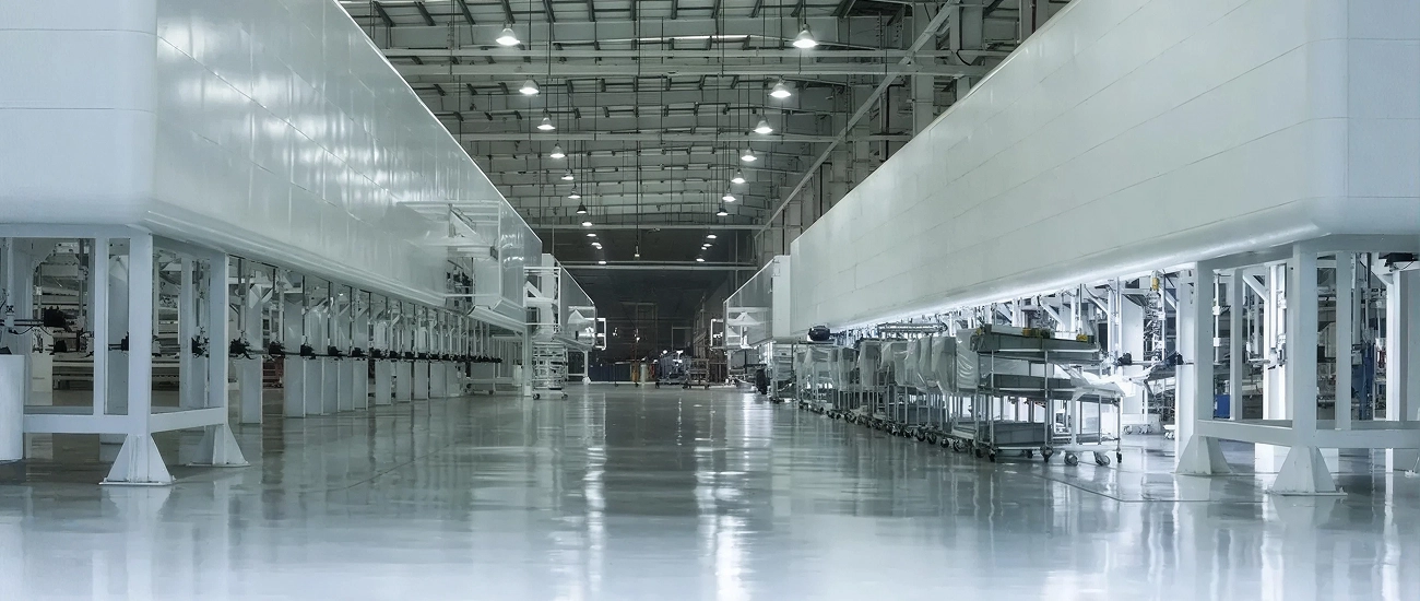 Zontes motos Argentina - interior de planta industrial con líneas de producción, estructuras blancas y piso reflectante